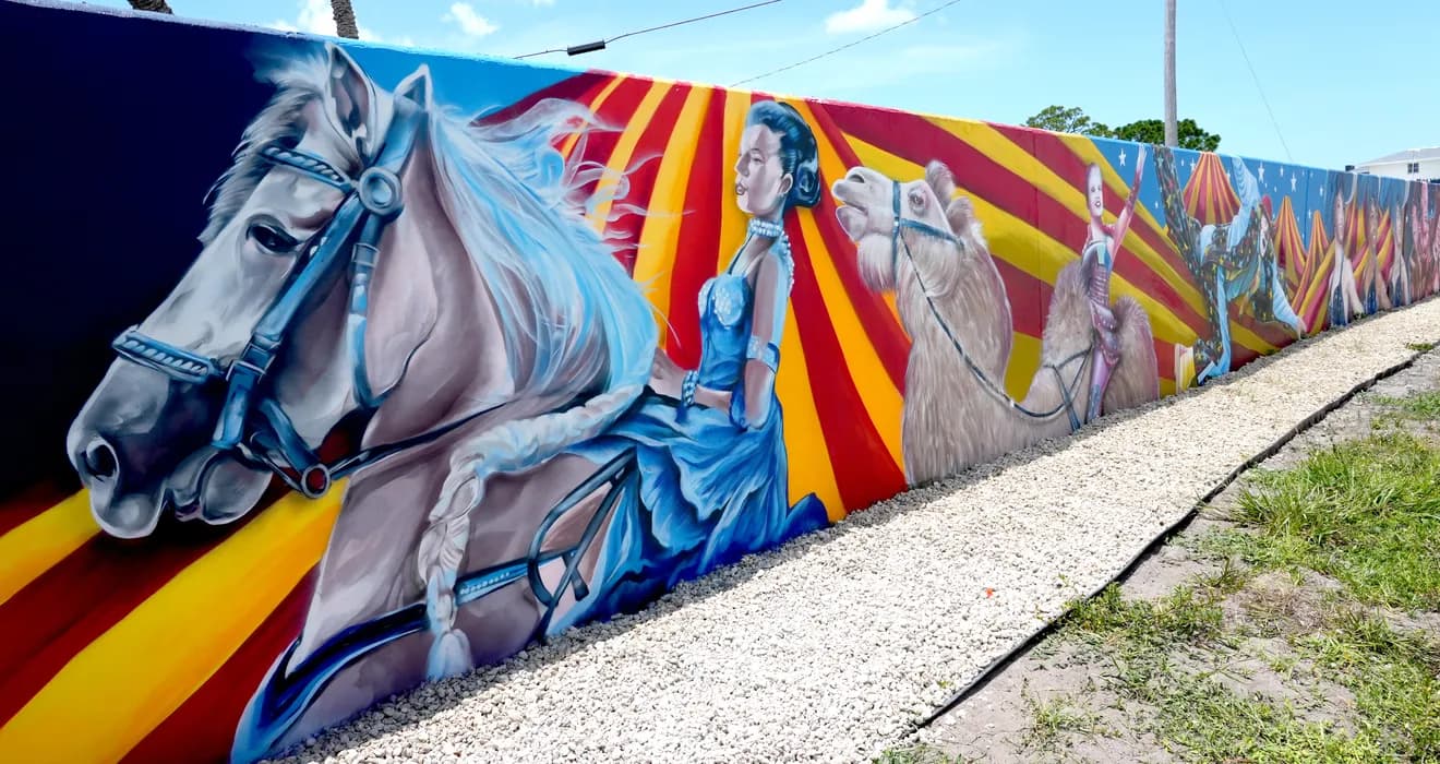 Wide view of circus-themed mural by Mark Francis Bulk Styles on an outdoor wall