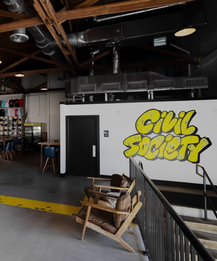 Civil Society Brewing Co interior mural by Bulk Styles—yellow graffiti lettering on white wall in brewery taproom