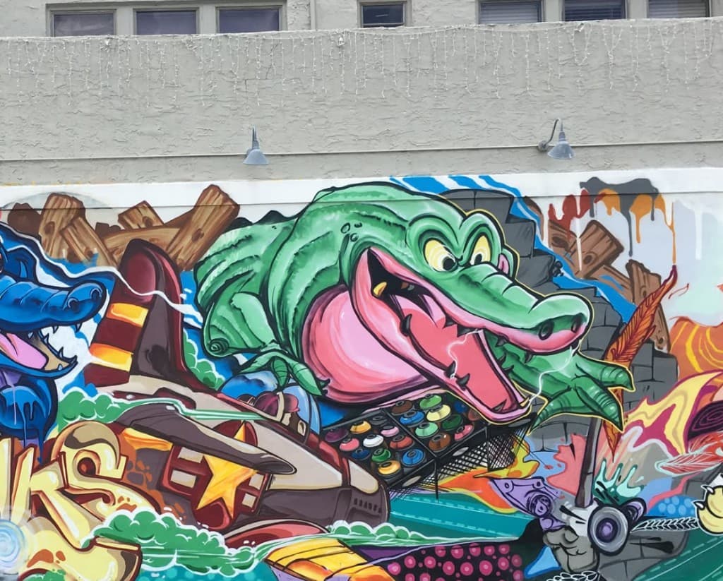 Close up of green alligator character in Clematis Street mural on the Respectable Street building in West Palm Beach by Bulk Styles