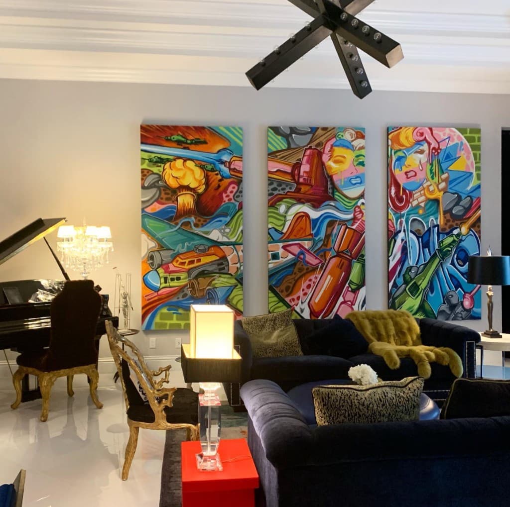 Bulk Styles original canvases in a living space — pop art and graffiti style triptych on wall above sofa