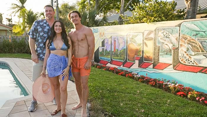 people standing in front of the completed Greetings From Jupiter mural in Jupiter Florida painted by Mark Francis Bulk Styles