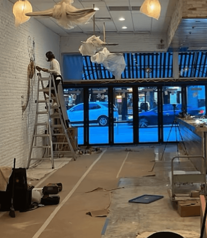 mural artist Mark Francis painting a restaurant wall mural inside Lynora's in West Palm Beach Florida