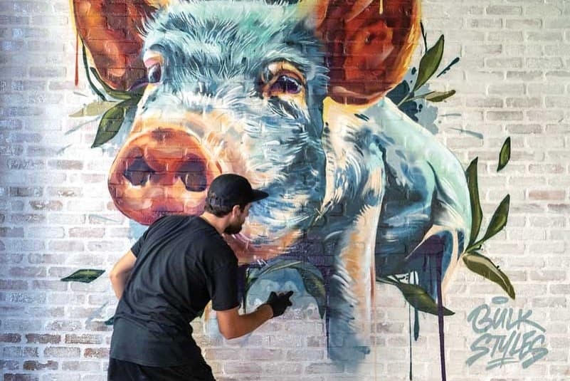 mural artist Mark Francis Bulk Styles painting pig mural at Parched Pig craft beer bar