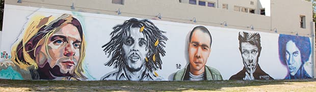 Large-scale public art mural of music icons—Kurt Cobain, Bob Marley, David Bowie, Prince, and more on an outdoor wall