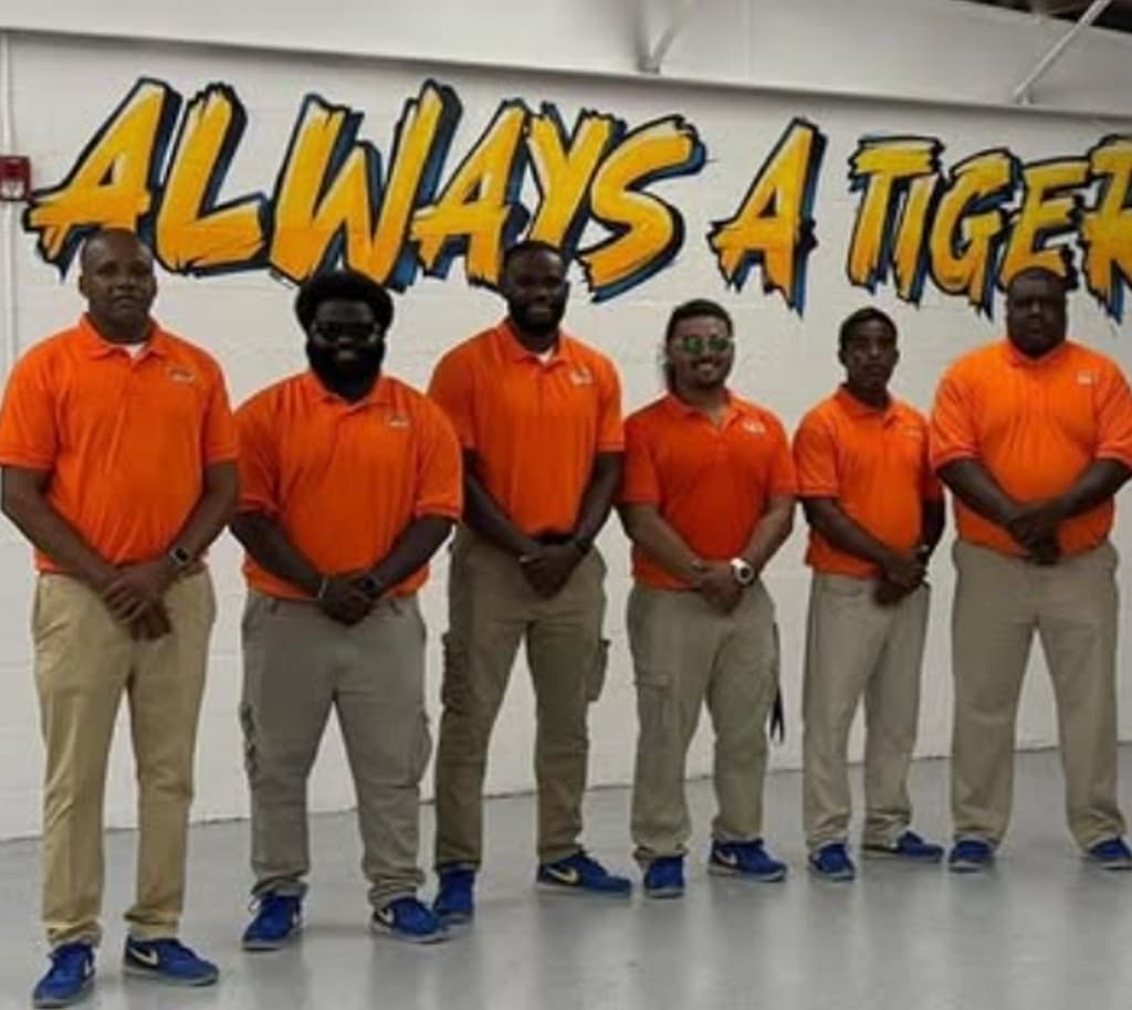 Team in front of Always a Tiger mural—creative programs that engage and inspire