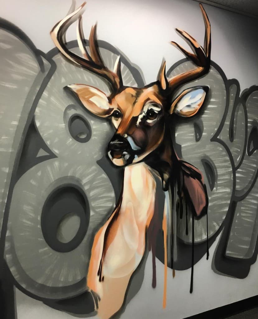 Finished deer buck mural with antlers, warm brown and tan tones, graffiti-style background and paint drips