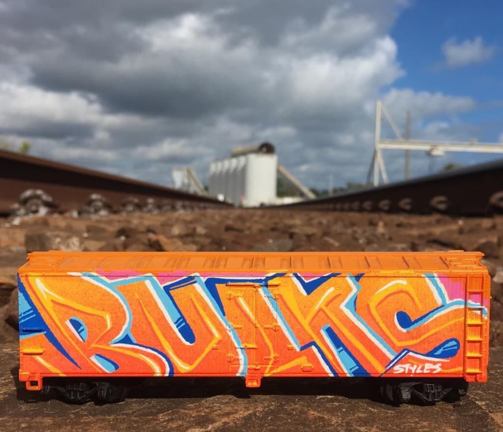 Bulk Styles graffiti artwork painted on a miniature train boxcar placed on railroad tracks