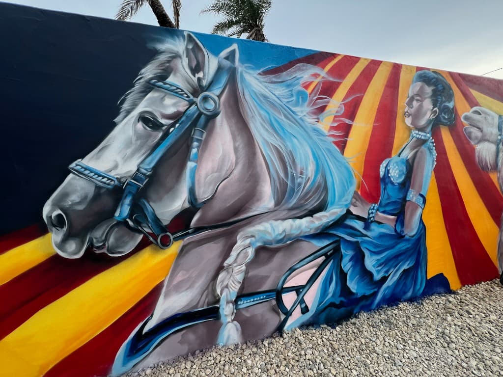 Circus themed mural featuring a horse and performer riding in front of circus tent stripes painted by Mark Francis of Bulk Styles