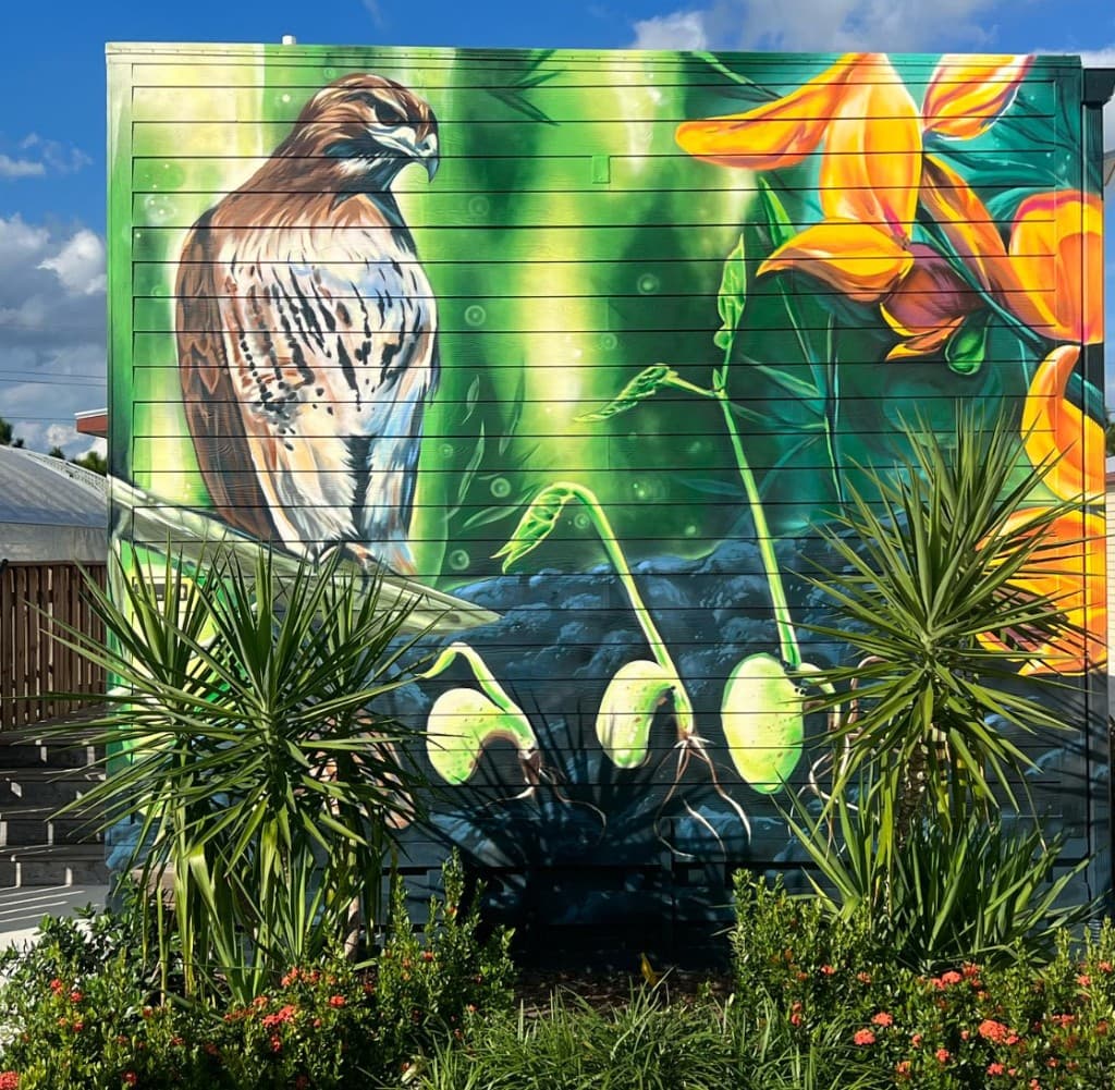 section of the Kai Kai Farm agriculture mural featuring a hawk and flowers painted by mural artist Mark Francis Bulk Styles