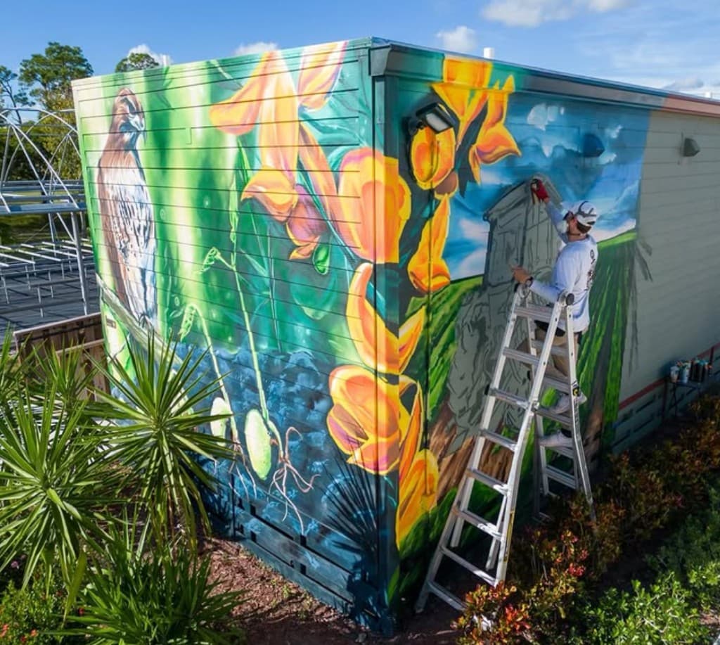 Mark Francis of Bulk Styles painting the Kai Kai Farm agriculture mural during installation