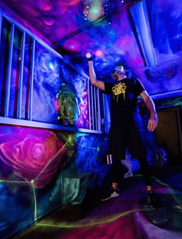 Mark Francis (Bulk Styles) painting a vibrant cosmic themed mural using spray paint