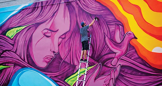 Mark Francis painting a large-scale mural