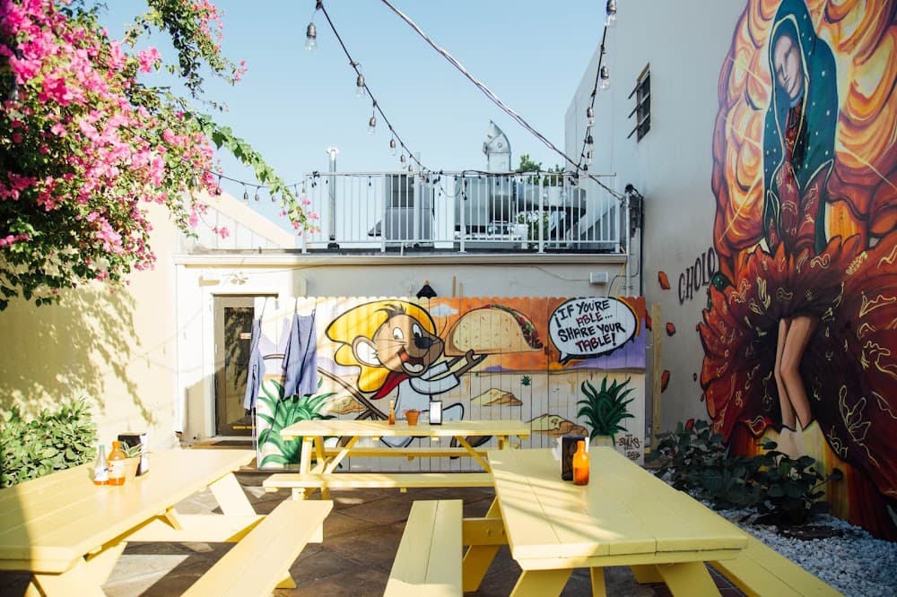 Outdoor restaurant patio with large colorful commercial murals that enhance the dining space and customer experience